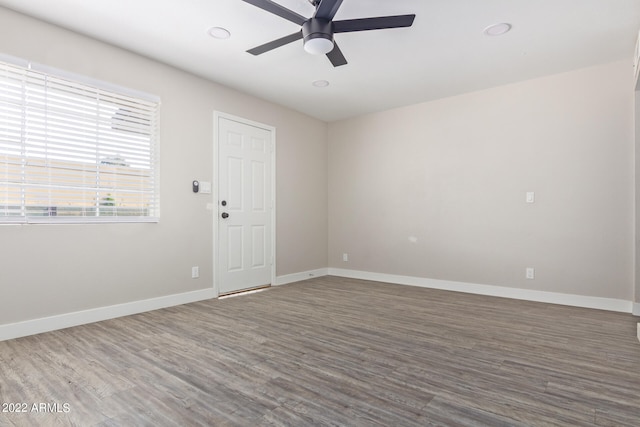 empty room with ceiling fan and dark wood-type flooring