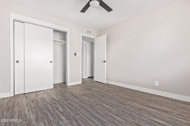 unfurnished bedroom with dark hardwood / wood-style flooring, ceiling fan, and a closet