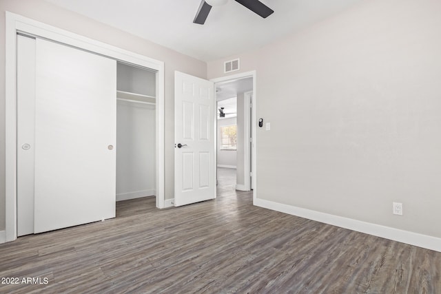 unfurnished bedroom featuring a closet, ceiling fan, and dark wood-type flooring