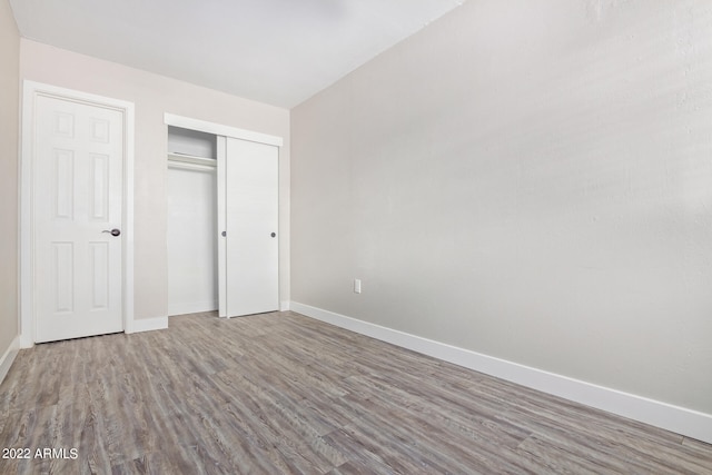 unfurnished bedroom featuring hardwood / wood-style floors and a closet