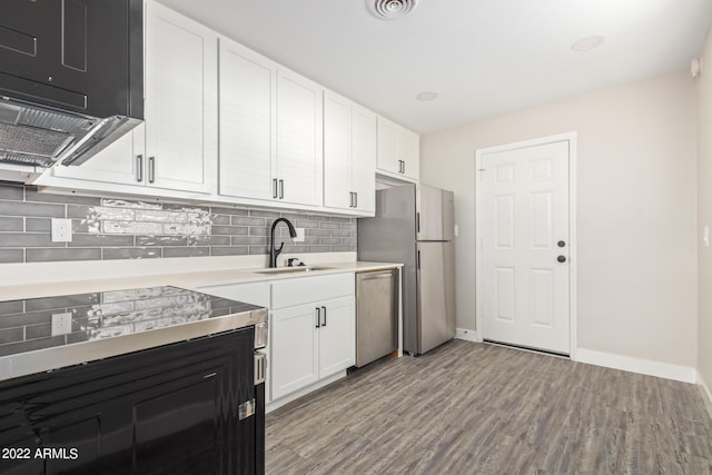 kitchen featuring appliances with stainless steel finishes, white cabinets, light hardwood / wood-style floors, and sink