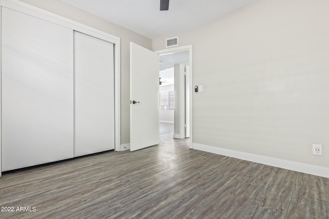 unfurnished bedroom with ceiling fan, hardwood / wood-style floors, and a closet