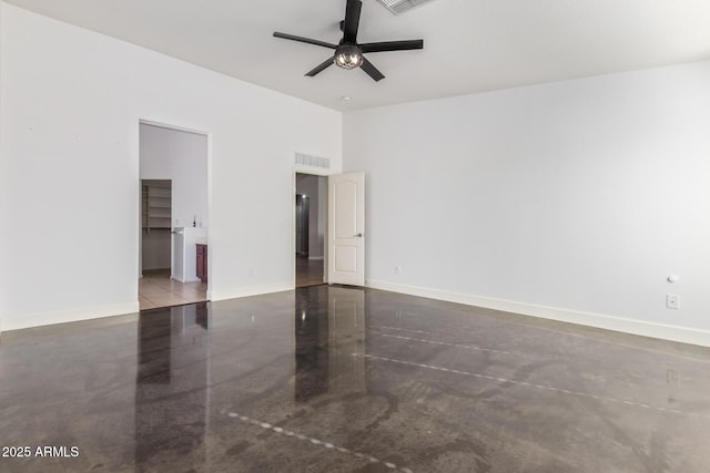 empty room with ceiling fan and concrete floors