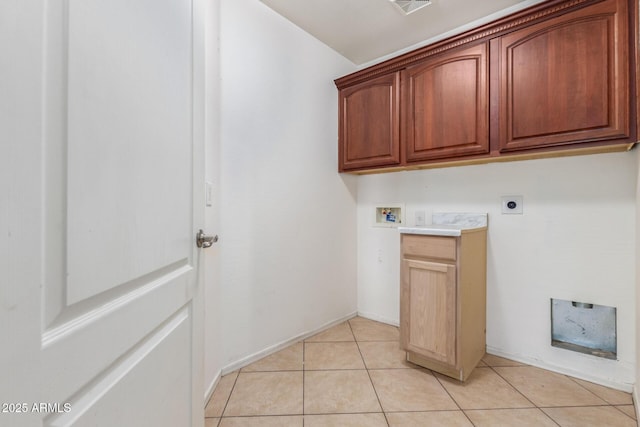 clothes washing area featuring electric dryer hookup, hookup for a washing machine, light tile patterned floors, and cabinets