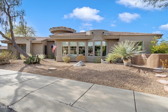 view of front of house with fence and stucco siding