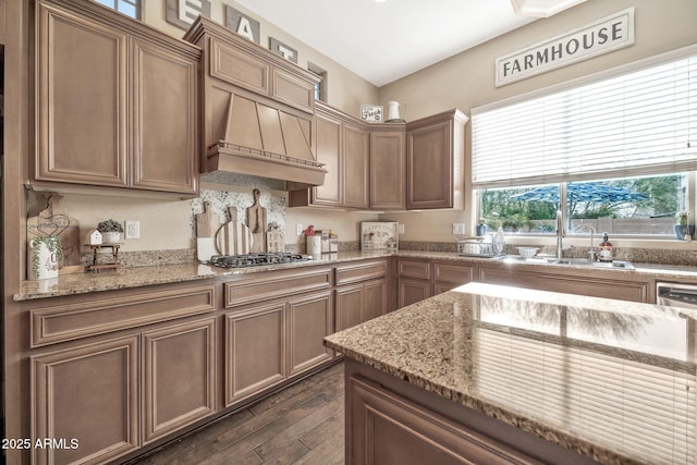 kitchen featuring light stone counters, premium range hood, dark hardwood / wood-style floors, and stainless steel gas stovetop