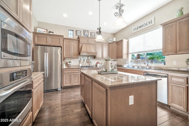 kitchen featuring appliances with stainless steel finishes, dark hardwood / wood-style floors, hanging light fixtures, and a center island