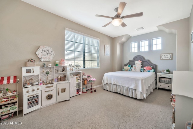 carpeted bedroom with ceiling fan and multiple windows