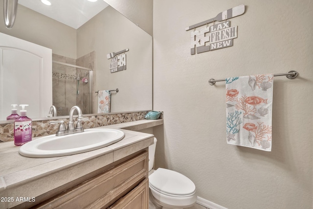 bathroom with an enclosed shower, vanity, and toilet