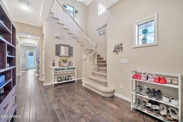 stairway featuring a high ceiling and wood-type flooring