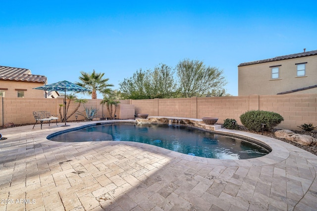 view of swimming pool with pool water feature and a patio