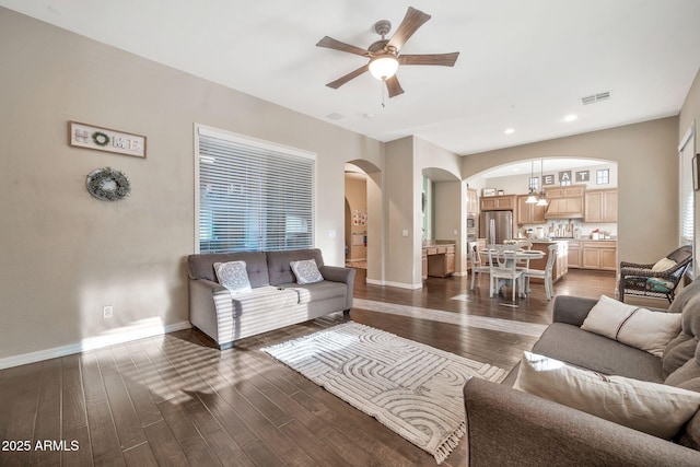 living room with ceiling fan and dark wood-type flooring