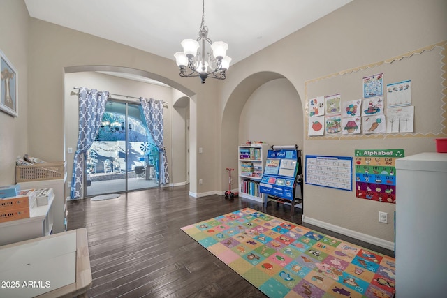 playroom with dark hardwood / wood-style flooring and a notable chandelier