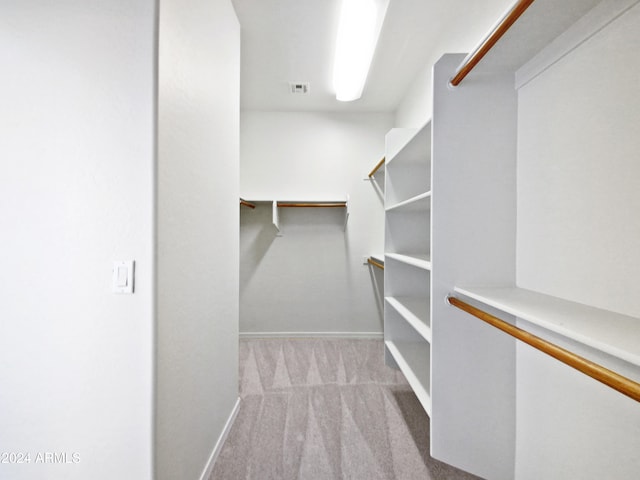 walk in closet featuring light carpet