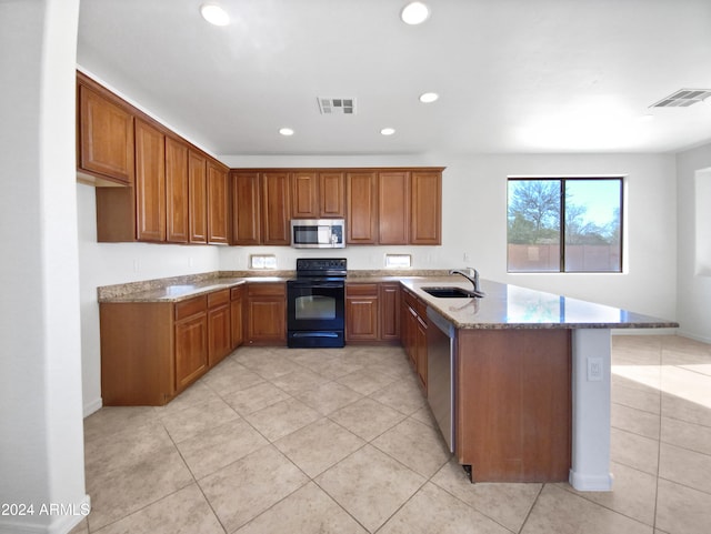 kitchen with light stone counters, kitchen peninsula, sink, light tile patterned floors, and appliances with stainless steel finishes