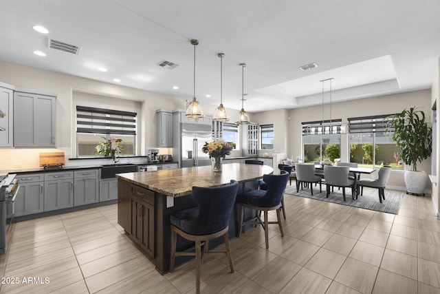 20795 W San Juan Ave, Buckeye, AZ 85396 - kitchen featuring stainless steel built in fridge, a sink, gray cabinetry, a kitchen island, and plenty of natural light