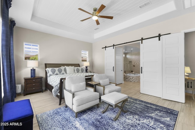 20795 W San Juan Ave, Buckeye, AZ 85396 - bedroom featuring a barn door, a raised ceiling, wooden ceiling, ensuite bathroom, and ceiling fan
