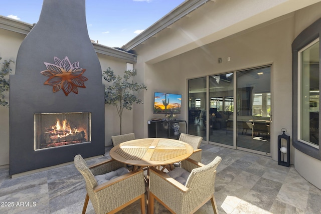20795 W San Juan Ave, Buckeye, AZ 85396 - view of patio / terrace featuring outdoor dining area and a warm lit fireplace