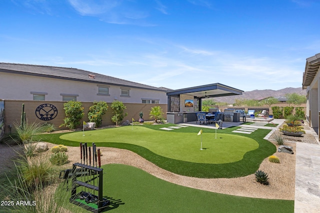 20795 W San Juan Ave, Buckeye, AZ 85396 - view of home's community with a putting green, a fenced backyard, and a patio