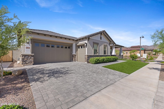 20795 W San Juan Ave, Buckeye, AZ 85396 - view of front facade featuring stone siding, an attached garage, decorative driveway, and stucco siding