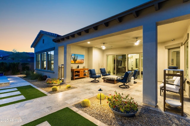 20795 W San Juan Ave, Buckeye, AZ 85396 - back of house featuring a patio, stucco siding, ceiling fan, and outdoor lounge area