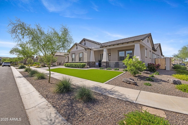 20795 W San Juan Ave, Buckeye, AZ 85396 - craftsman inspired home featuring stucco siding, stone siding, covered porch, and a front yard