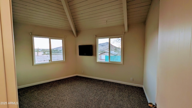 empty room featuring wooden ceiling, vaulted ceiling with beams, and dark carpet