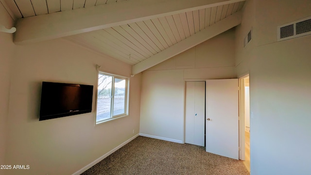 unfurnished bedroom featuring carpet flooring, a closet, and vaulted ceiling with beams