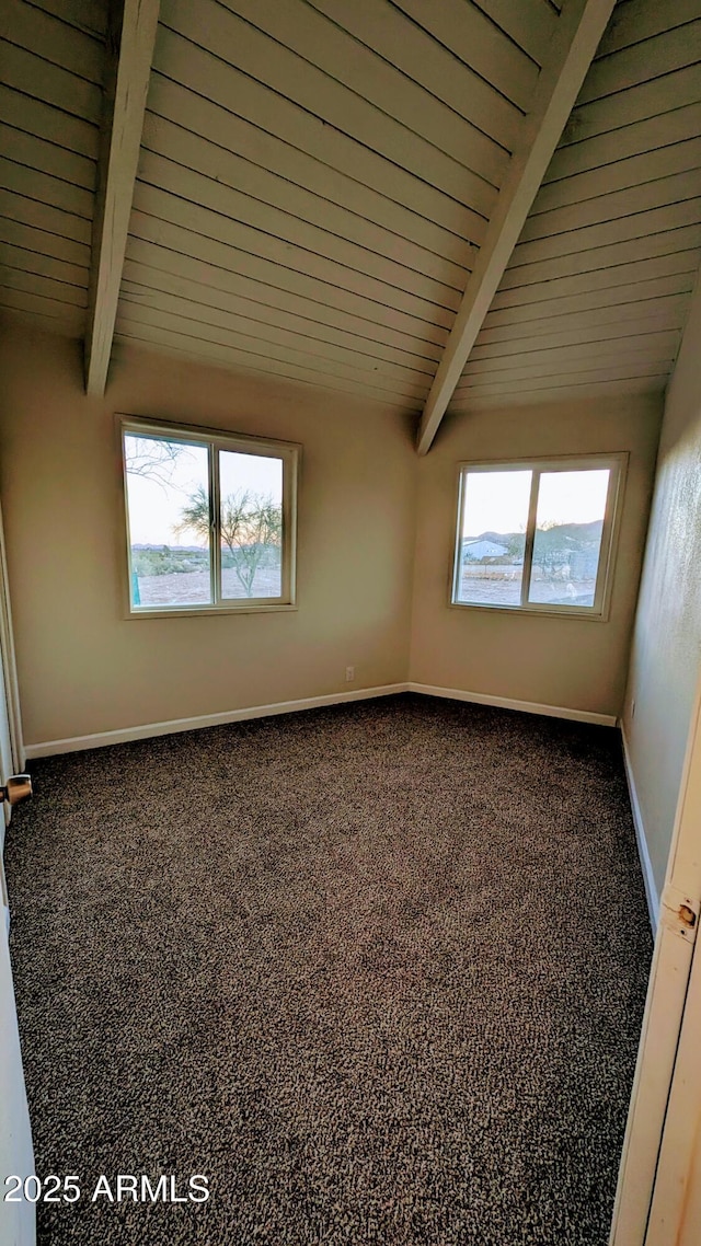 carpeted spare room featuring beam ceiling, wooden ceiling, and a wealth of natural light