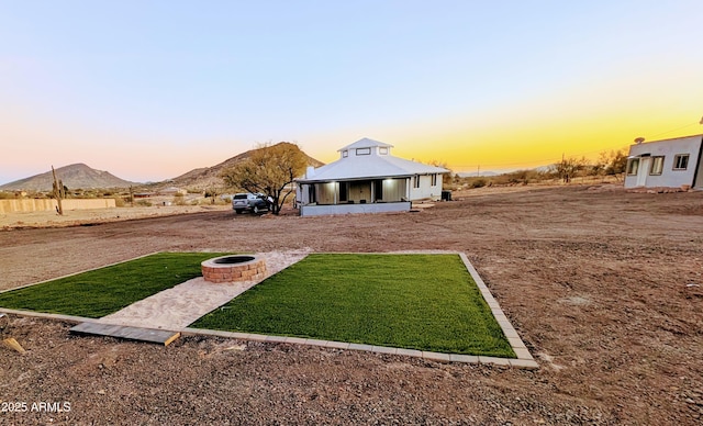 yard at dusk with an outdoor fire pit and a mountain view