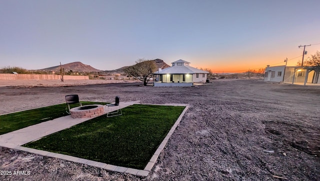 yard at dusk with a gazebo, a fire pit, and a mountain view