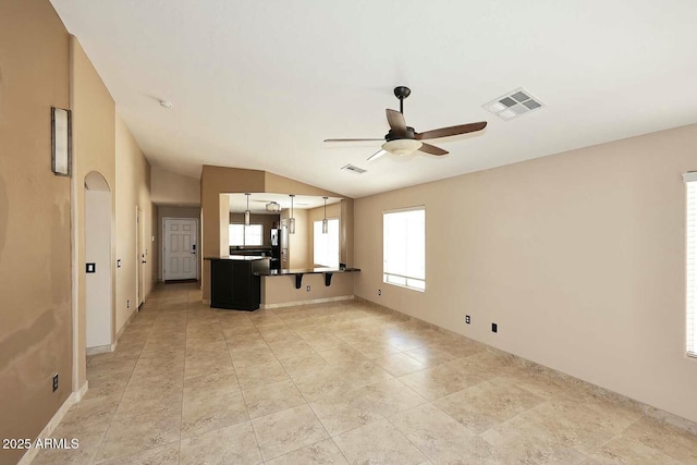 unfurnished living room featuring lofted ceiling, light tile patterned floors, a ceiling fan, and visible vents