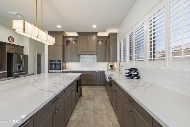 5332 E Thunder Hawk Rd, Cave Creek, AZ 85331 - kitchen with appliances with stainless steel finishes, decorative backsplash, glass insert cabinets, pendant lighting, and light stone counters