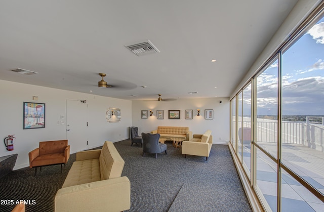 carpeted living area featuring visible vents, baseboards, and a ceiling fan