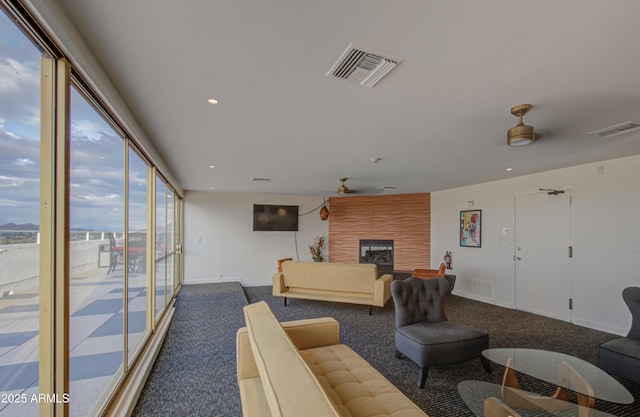 living area with a fireplace, visible vents, and carpet floors