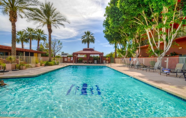 community pool featuring a gazebo, a patio area, and fence