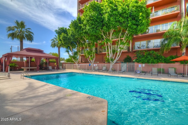 community pool featuring a gazebo, a patio area, and fence