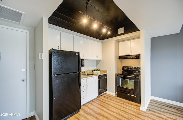 kitchen with visible vents, black appliances, under cabinet range hood, light wood-type flooring, and white cabinetry