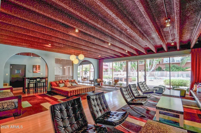 living room featuring arched walkways and wood finished floors