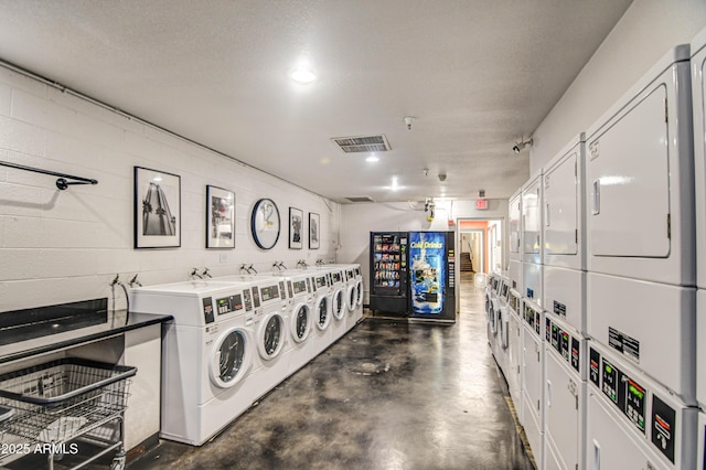 common laundry area featuring stacked washer / dryer, independent washer and dryer, concrete block wall, and visible vents