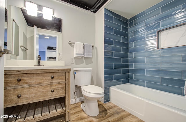 bathroom featuring vanity, wood finished floors, baseboards, tub / shower combination, and toilet