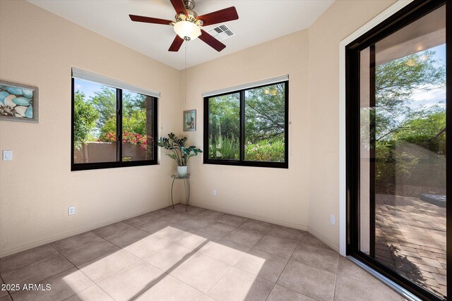 7445 E Eagle Crest Dr Unit 1015, Mesa, AZ 85207 - spare room with healthy amount of natural light, a ceiling fan, light tile patterned floors, and baseboards