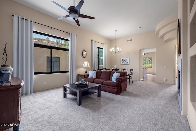 7445 E Eagle Crest Dr Unit 1015, Mesa, AZ 85207 - carpeted living area with ceiling fan, arched walkways, a chandelier, and baseboards