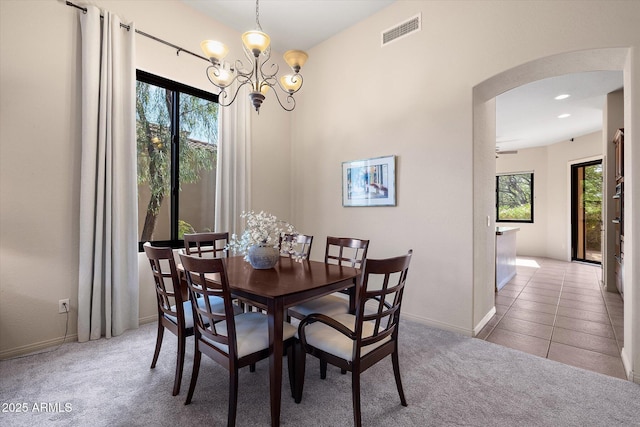 7445 E Eagle Crest Dr Unit 1015, Mesa, AZ 85207 - dining space featuring arched walkways, a chandelier, light carpet, and baseboards