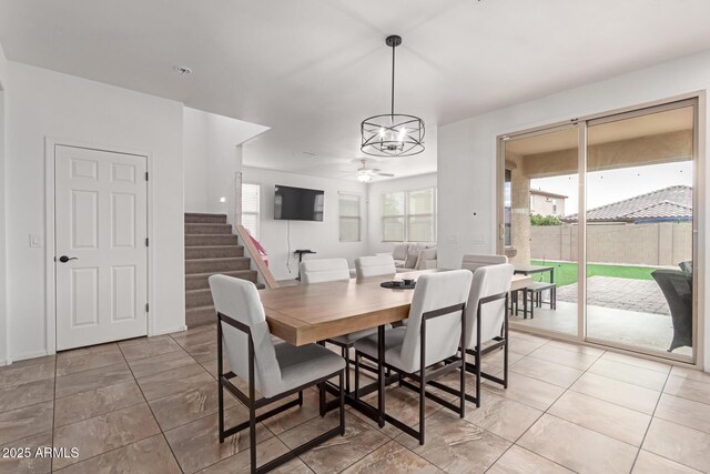 dining space with ceiling fan with notable chandelier