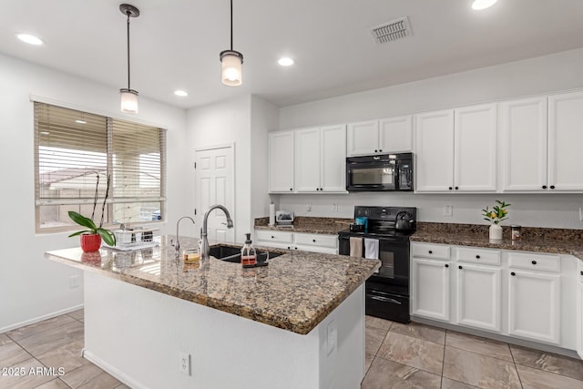 kitchen featuring pendant lighting, sink, dark stone countertops, black appliances, and a center island with sink