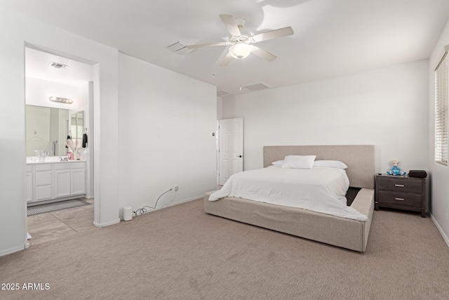 bedroom with connected bathroom, light colored carpet, and ceiling fan