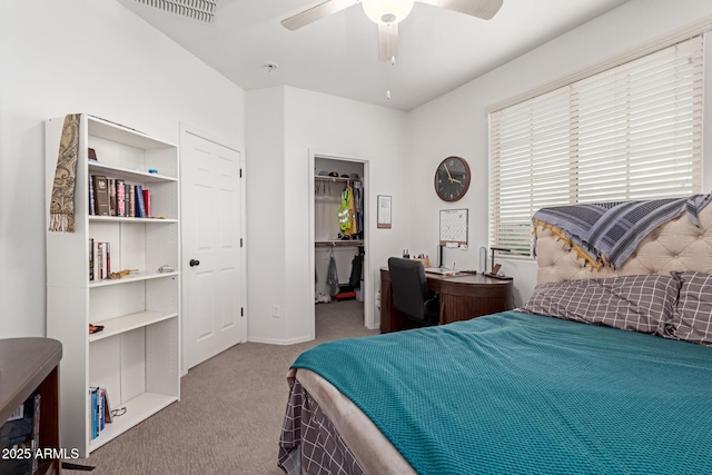 carpeted bedroom featuring a walk in closet, ceiling fan, and a closet