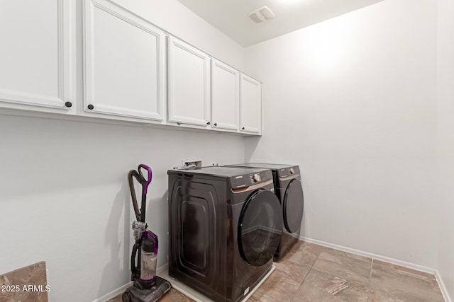 laundry room featuring cabinets and washing machine and dryer