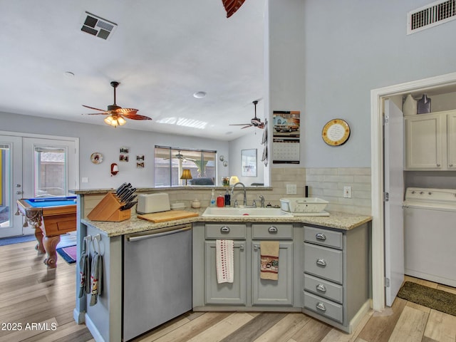 kitchen featuring dishwasher, washer / dryer, sink, gray cabinetry, and kitchen peninsula